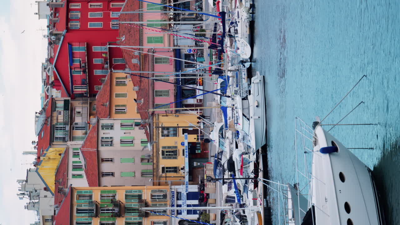 Nice, France - February 4, 2025: White boats docked in Port Lympia, overlooking the city. Vertical