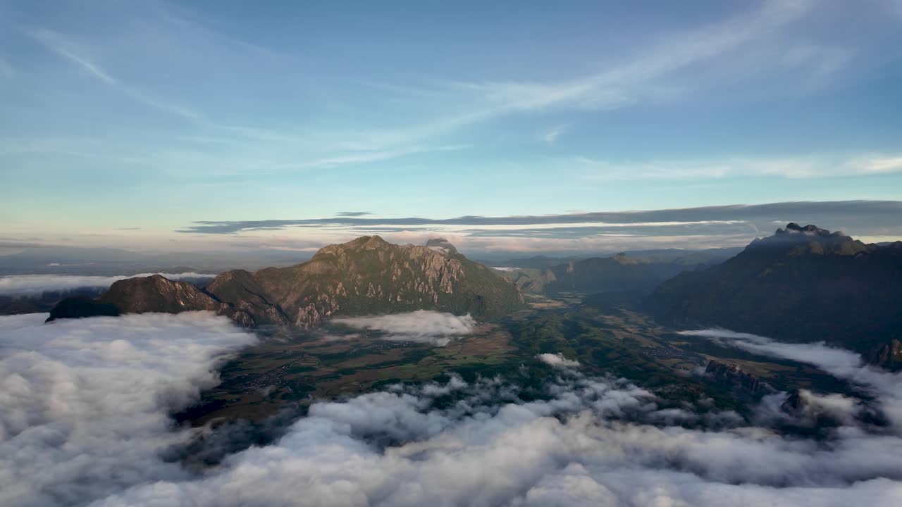 Laos landscape with mountains, forests, and valleys emerging from morning clouds