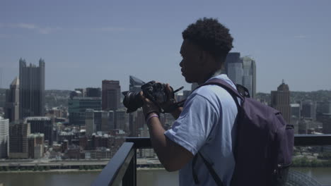 african american male looks out over city skyline and takes photographs stabilized shot in uhd 4k