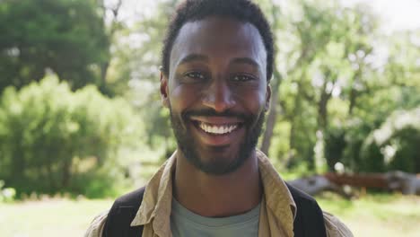 portrait of happy african american man looking at camera in park, slow motion