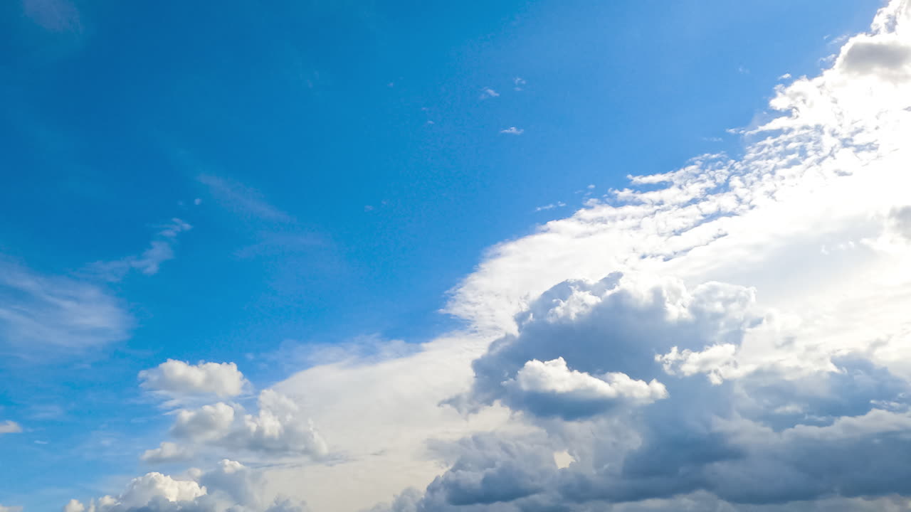 Bright white shining clouds lit by the hot summer sun. Cumulus and spindrift clouds moving in the sky timelapse.