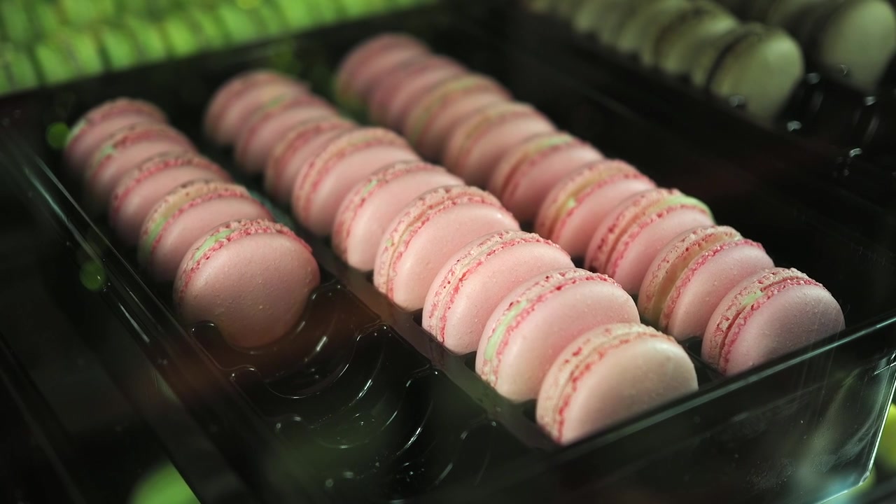 Rows of Pink Macarons Displayed in a Bakery Case