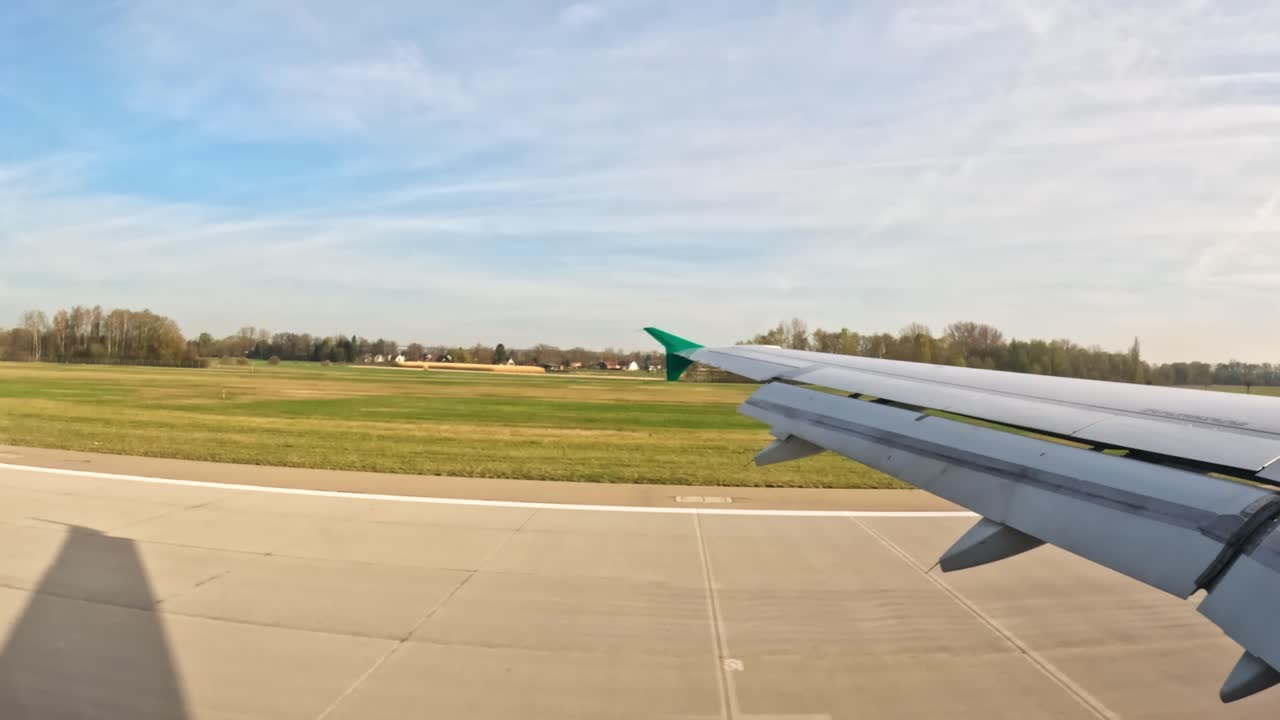 Landing approach from an airplane wing landing, green fields visible in the distance