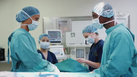 surgical team working on patient in hospital operating theatre