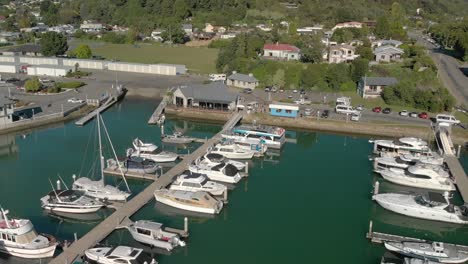 Havelock,-New-Zealand-marina-with-boats,-sailboats,-yachts,-restaurant-and-people---Aerial-Drone