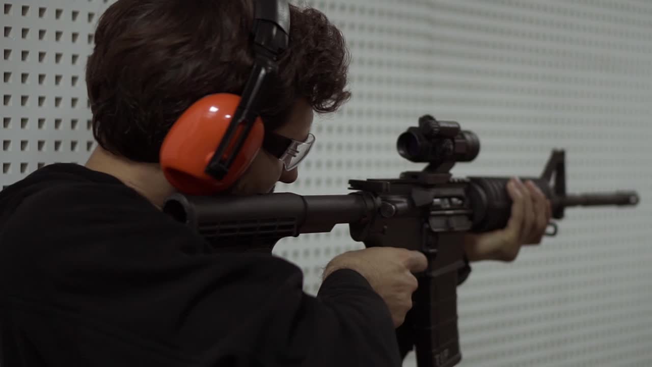 一個人戴著耳機在射擊場開槍