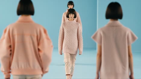 charming fashion showcase: elegant models walk the runway in cozy knitwear against a soft blue backdrop, emphasizing chic autumn styles with delicate details