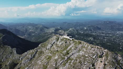 the mausoleum of njegoš in montenegro perched atop rugged mountains, offering breathtaking views of the surrounding landscape and clear skies