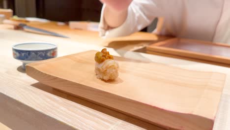 chef places sushi on wooden board