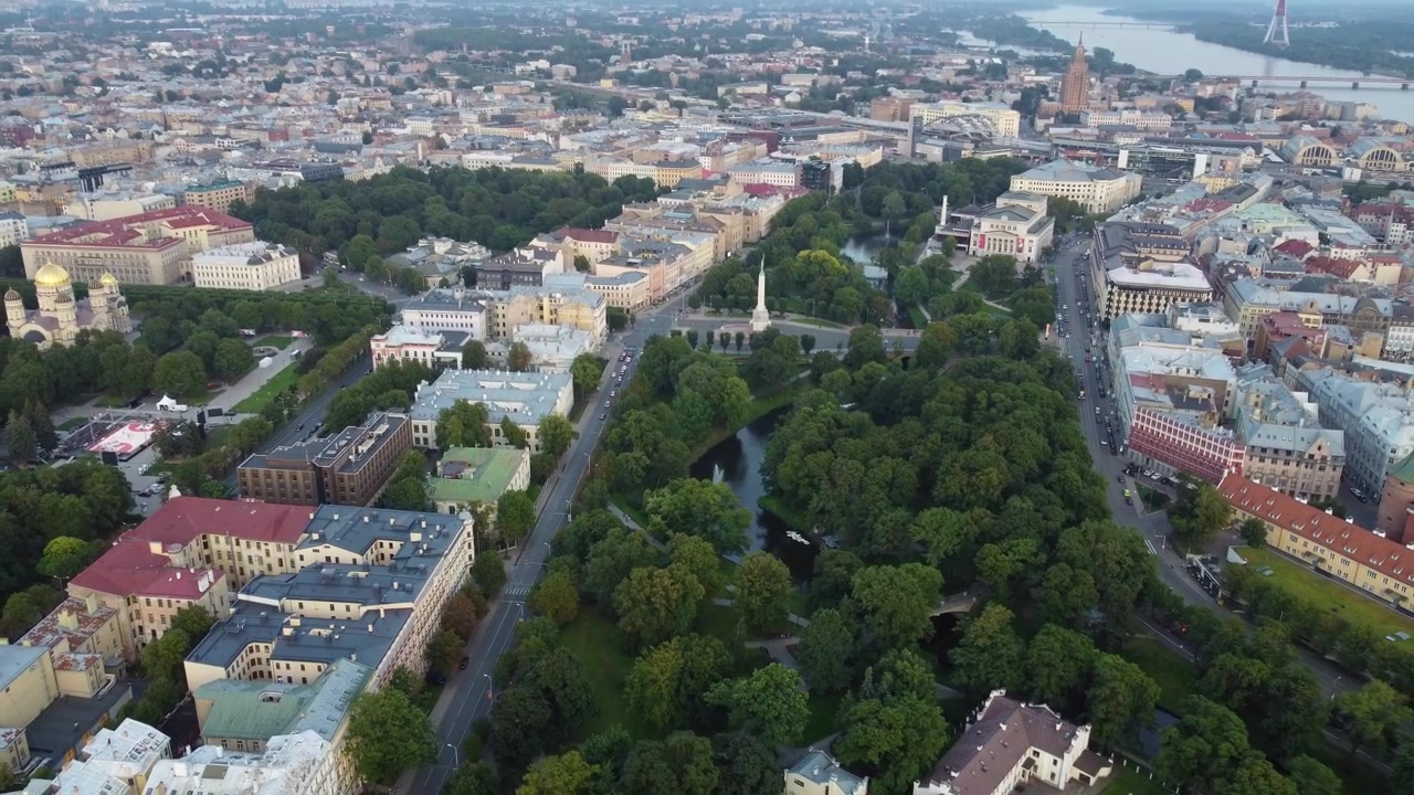 Belo parque verde e canal de água cercados pela paisagem urbana de Riga, vista aérea.