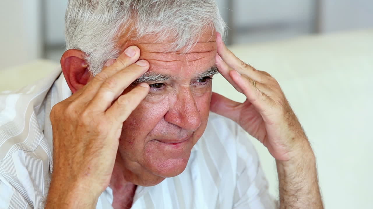 소파에 앉아 있는 불행한 노인