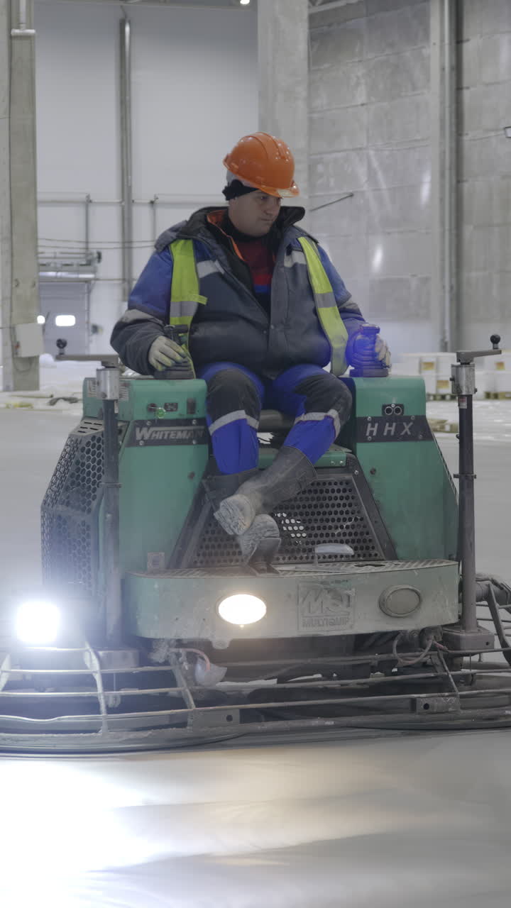 trabajador que opera una máquina de acabado de pisos de hormigón