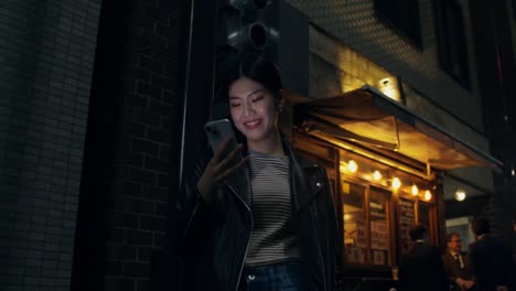 woman using phone at night in a city street