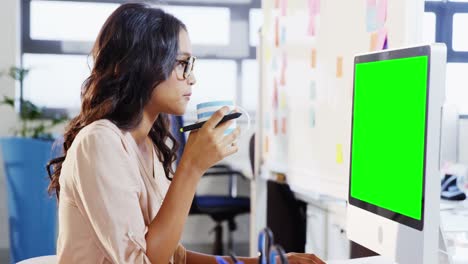 Female-graphic-designer-working-on-computer-while-coffee