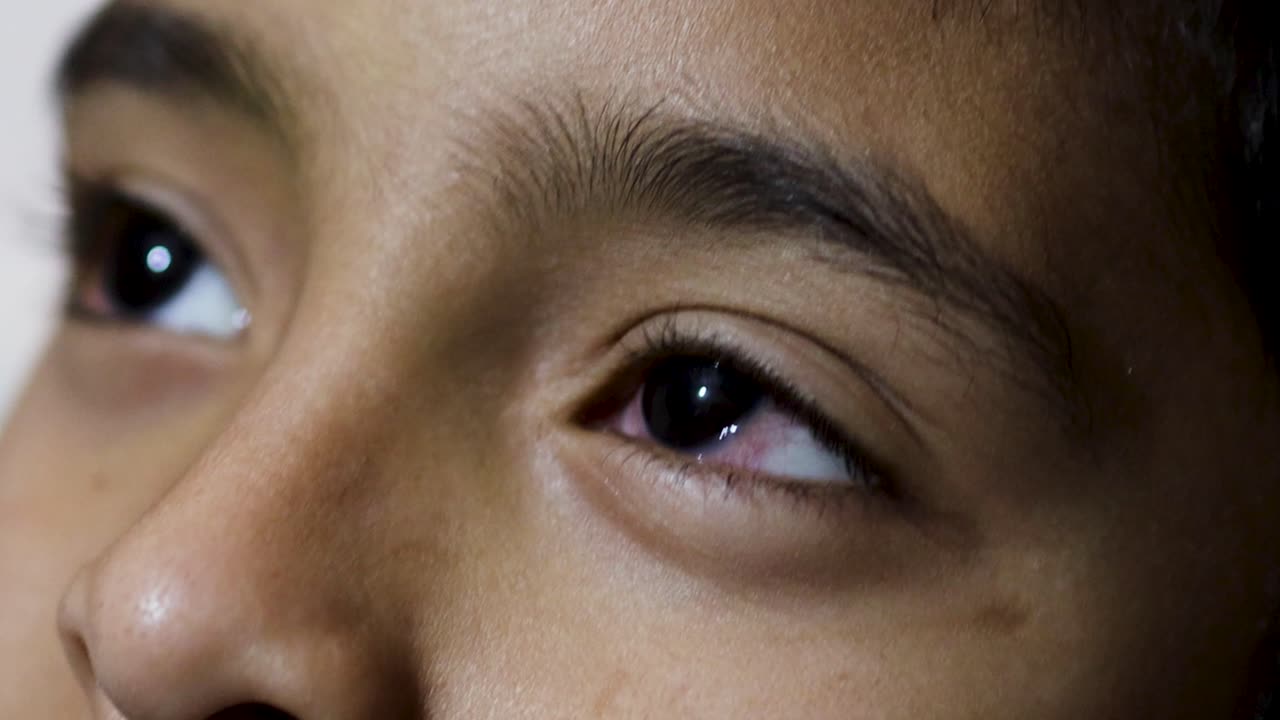 어린 아이는 밤에 흐릿한 배경으로 온라인 게임을 한 후 눈이 니다.