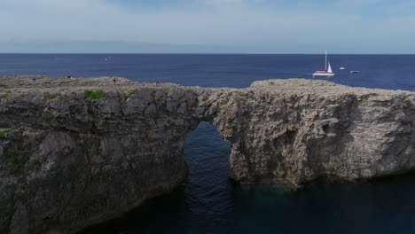 Drone-flying-around-the-cliffs-of-Port-den-Gil-at-sunset-coastline-of-Menorca