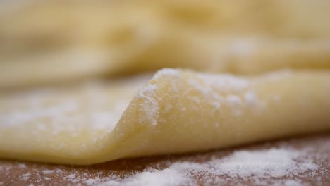 Sprinkling-compound-powder-on-readymade-faworki-angel-wings-macro