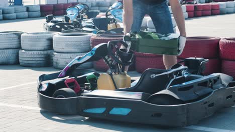 el mecánico del servicio de carreras de karts vierte combustible en el tanque.