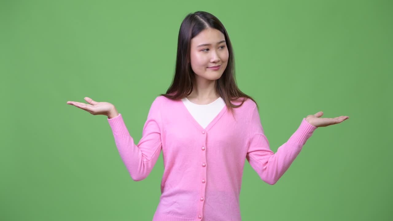 Young beautiful Asian woman choosing between left and right