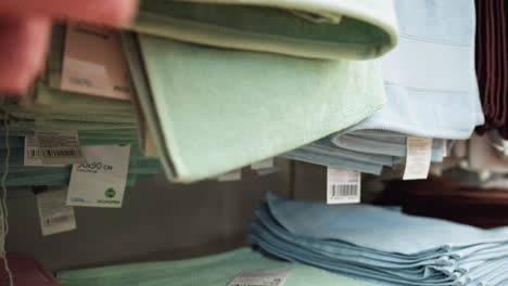 view of neatly arranged hand towels in various colors on store shelves., this video showcases the organized display of towels in a retail environment, highlighting their sizes and eco-friendly labels