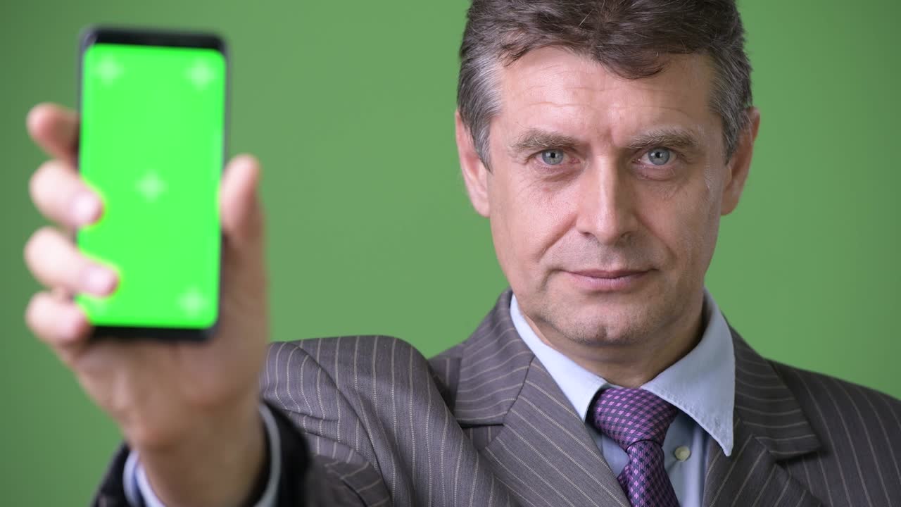 녹색 배경에 성숙한 잘생긴 사업가