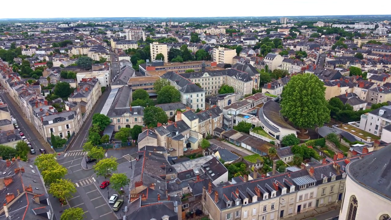 Drone che vola sopra il centro di Angers, passando la Chiesa di San Giuseppe e rivelando tetti, strade e il paesaggio urbano circostante.