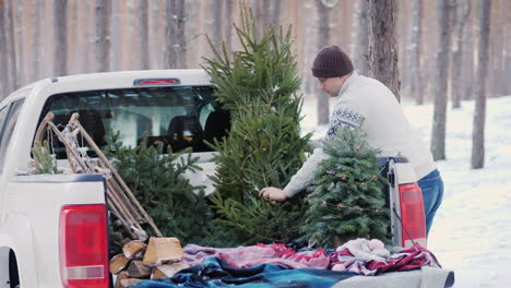 Ein-Junger-Mann-Verschifft-Einen-Neujahrsbaum-Auf-Der-Ladefläche-Eines-Pickups,-Der-Sich-Auf-Weihnachten-Vorbereitet