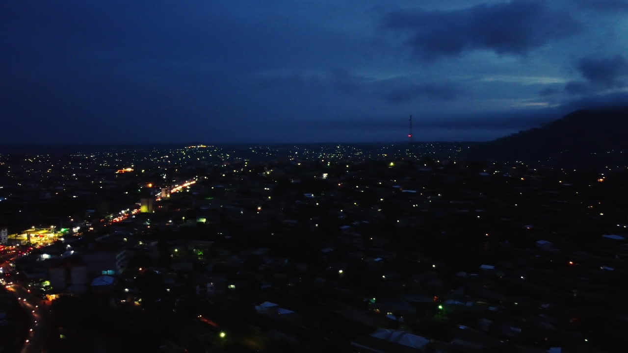 vista aérea panorámica sobre un barrio iluminado de etoug-ebe en la ciudad de yaundé, atardecer en camerún