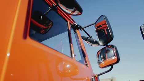 close-up of an orange truck's side with mirrors