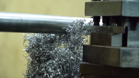 la fibra metálica está girando alrededor del gran taladro de acero motor de máquina de torno metálico, fabricante de tecnología en proceso de operación en la fábrica de plantas de fabricación de la industria. equipos de productos crudos en el almacén.