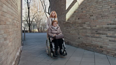 daughter supporting elderly mother in wheelchair