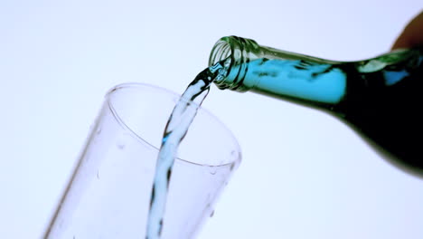 blue liquid pouring into glass