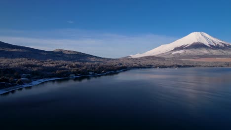 Mt-Fuji-Snow-Covered-Forest-And-Calm-Water-Lake-In-Winter-Drone