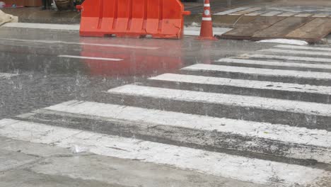 low angle view to the local street while heavy raining in rainy season with some cars driving, water wet splash on the road street surface with thunderstorm,natural background