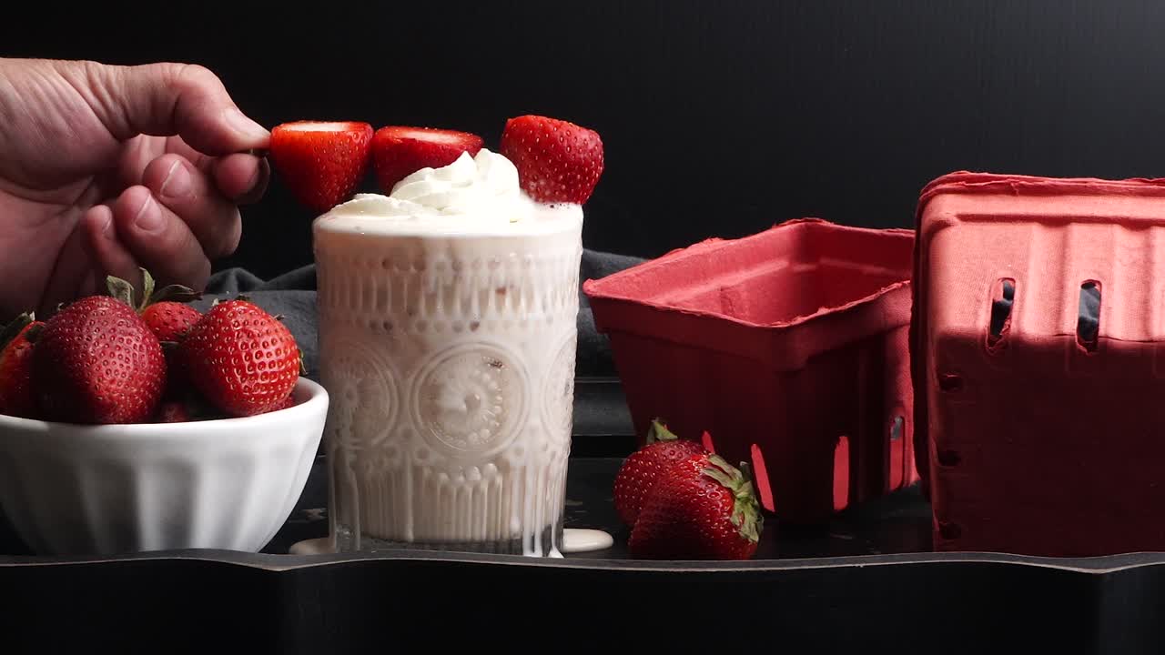 Pink cocktail drink with strawberry liqueur, vanilla vodka and cream. Party drink with strawberries. Fruit cocktail with fresh strawberries as a garnish. Cold and refreshing