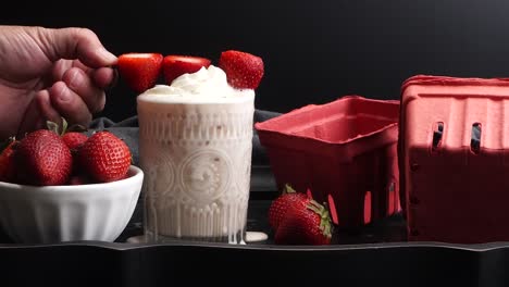 pink cocktail drink with strawberry liqueur, vanilla vodka and cream. party drink with strawberries. fruit cocktail with fresh strawberries as a garnish. cold and refreshing