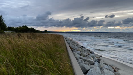 static shot of waves crashing on sandy beach shore on calm windy summer evening