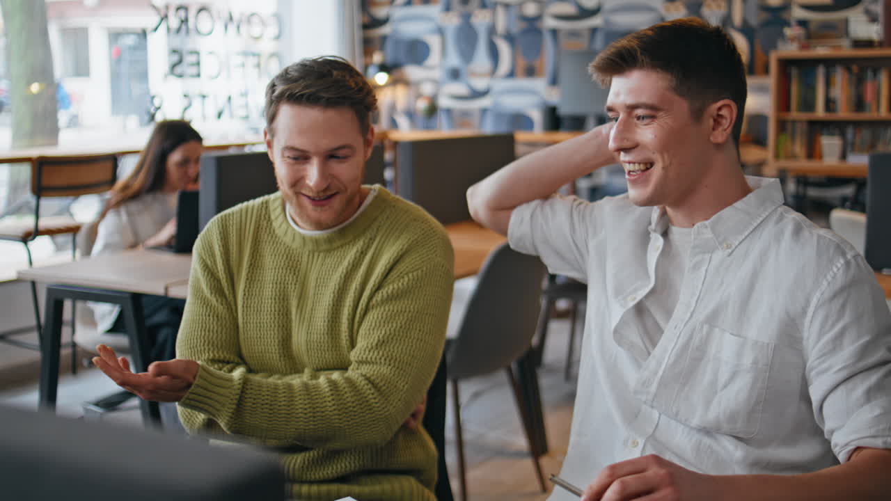 Happy coworkers looking laptop screen at office closeup. Creators talking call