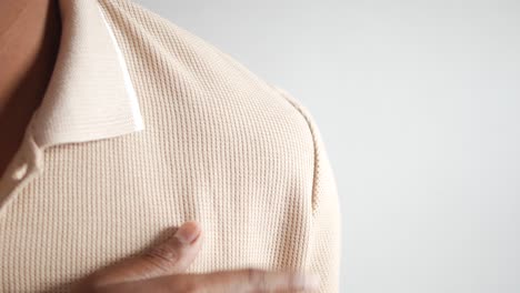 a close-up of a man's hand touching his shoulder.