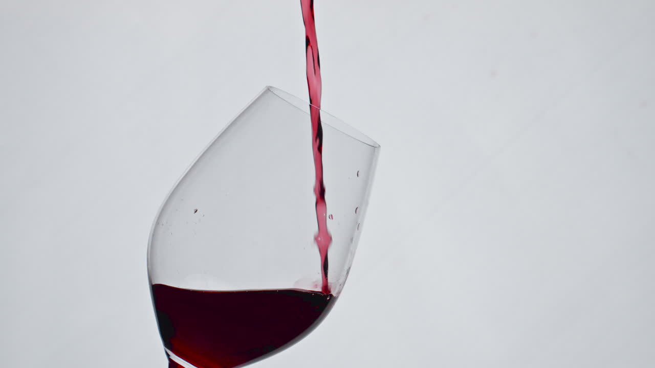 클로즈업 빨간 액체 채우기 와인 글래스 느린 동작. 컵 안에서 와인이 어지고