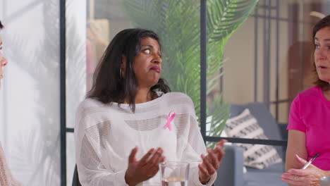 Mature-Woman-Wearing-Pink-Breast-Cancer-Awareness-Ribbon-Talking-At-Meeting-Of-Therapy-Support-Group-For-Cancer-Treatment-Patients-4