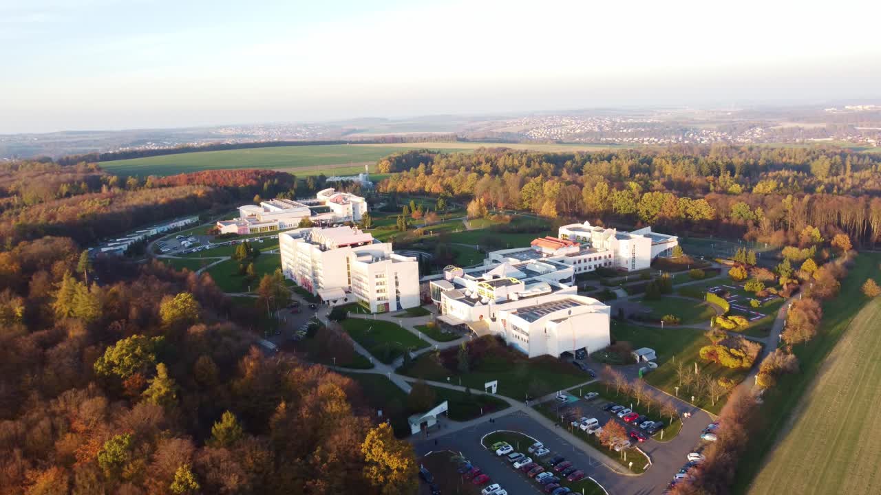 Aerial panoramic pullback from high angle of wellness building in Czech Republic, surrounded by vibrant autumnal colors in natural landscape