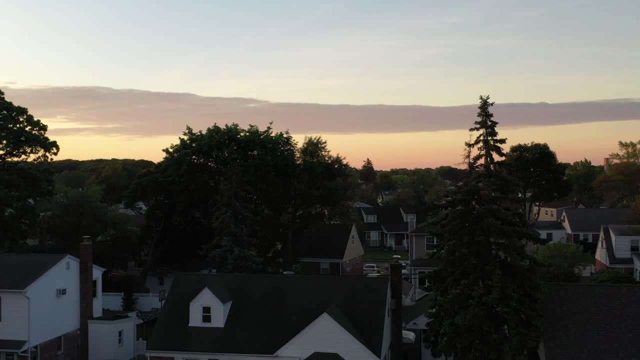 A low altitude view over a middle class suburban neighborhood on Long Island, NY at sunrise