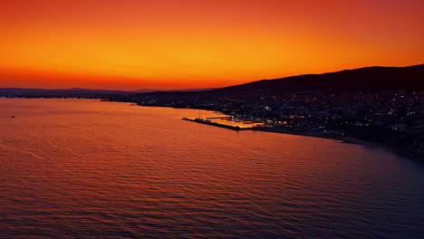 Coastal sunset in vibrant hues. Colorful sunset casts a warm glow over the calm sea and beach, illuminating the coastline in twilight