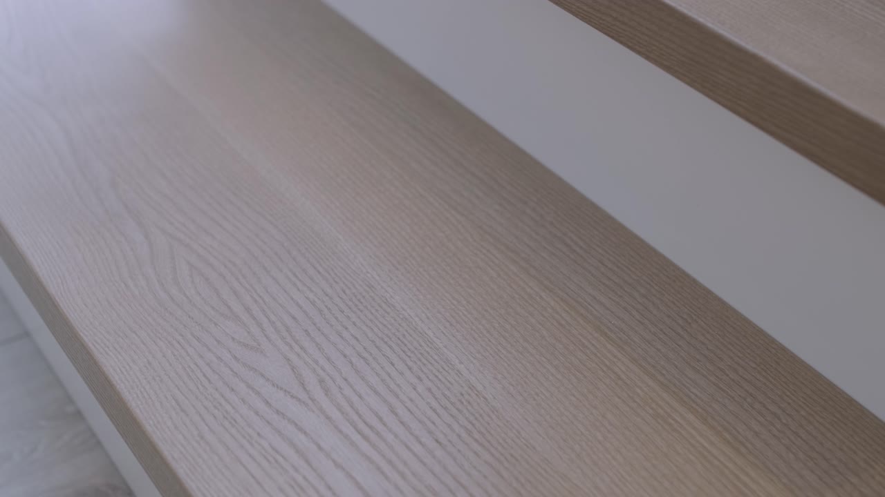 elegante escalera de madera con grano de madera detallado y ascensor blanco, que muestra la artesanía interior moderna