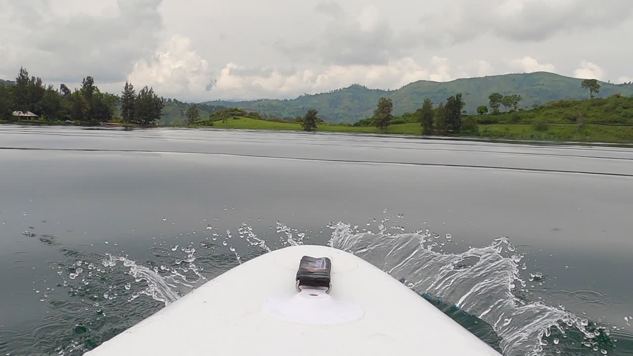 вид с паддлборда на озеро киву с небольшими волнами в зеленых джунглях с низкой точки зрения