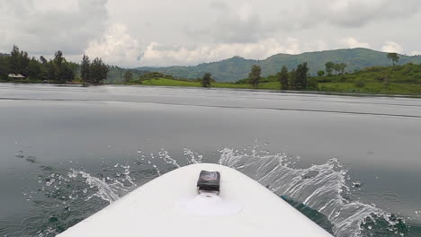 low pov paddleboard view of green jungle lake kivu with small waves