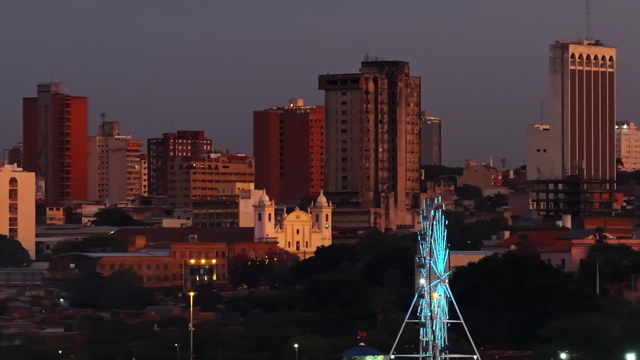Panoramic view of Metropolitan Cathedral white facade, university, Ferris wheel and Asuncion high rise buildings in downtown