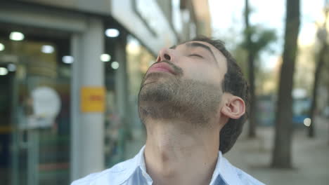 beautiful close-up shot of a young latin man eating sweets on a street in madrid in the afternoon in slow motion