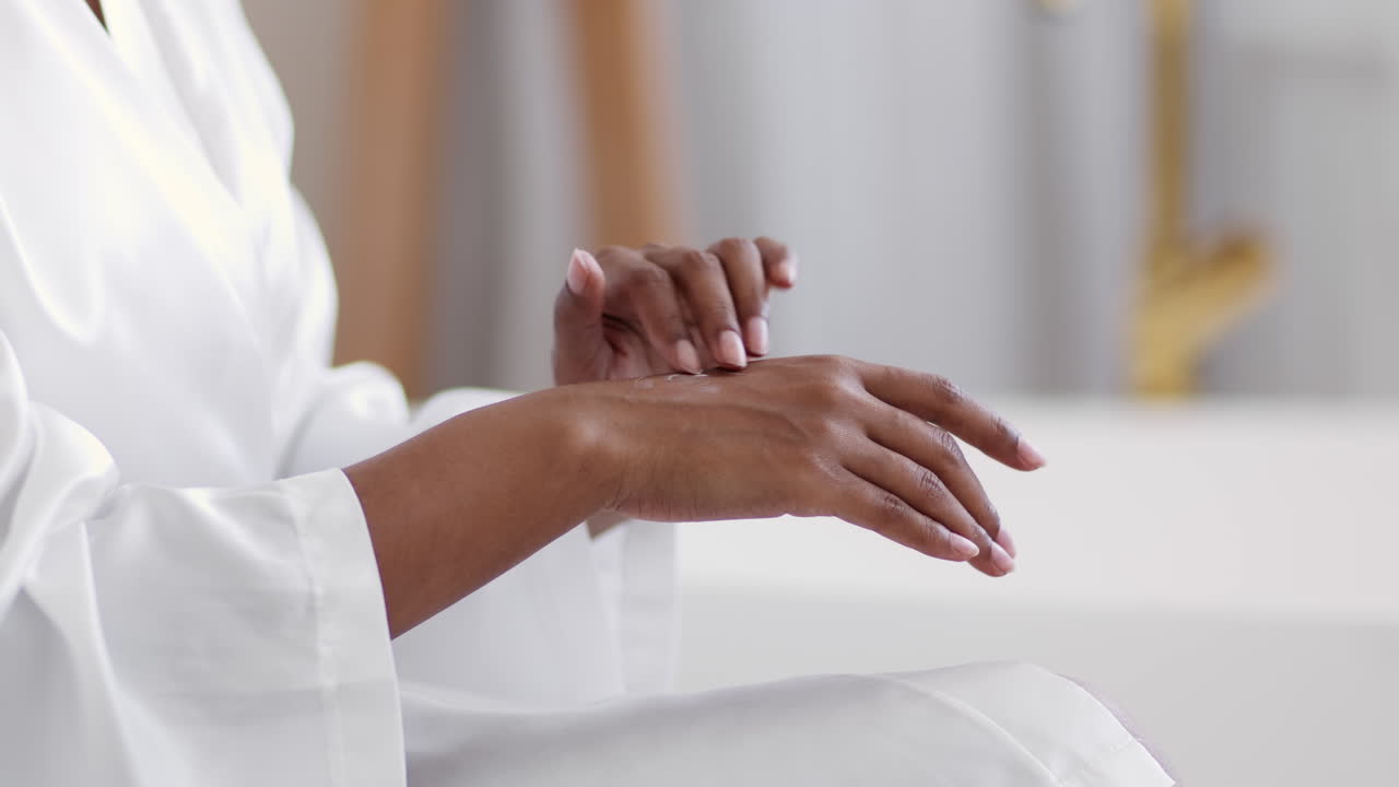 Kvinde påfører lotion på sine hænder på et badeværelse